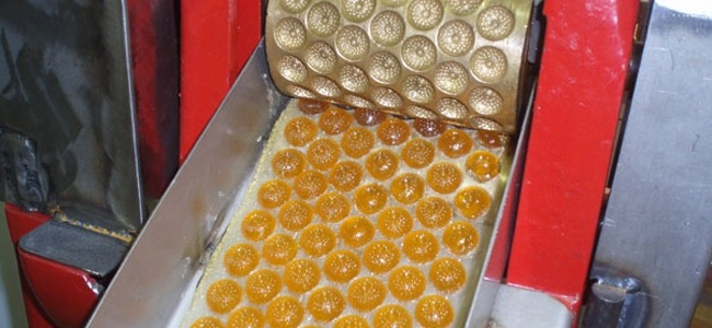 Moulage du bonbon au miel grâce à des moules, que l'on voit en partie haute de la photo