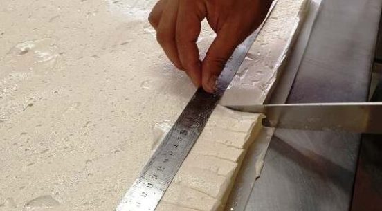Mesure manuelle de chaque guimauve au miel.puis découpe.